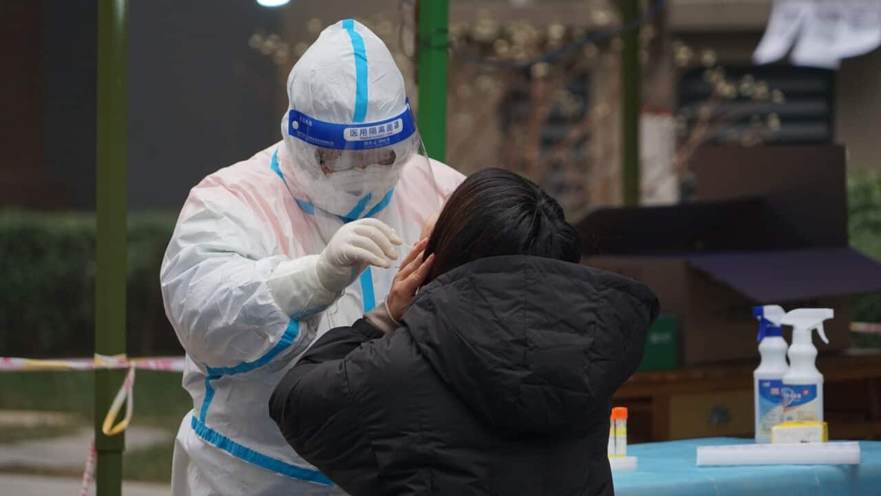 Citizens take nucleic acid tests at a closed community in Xi'an, which has been in lockdown for nearly two weeks