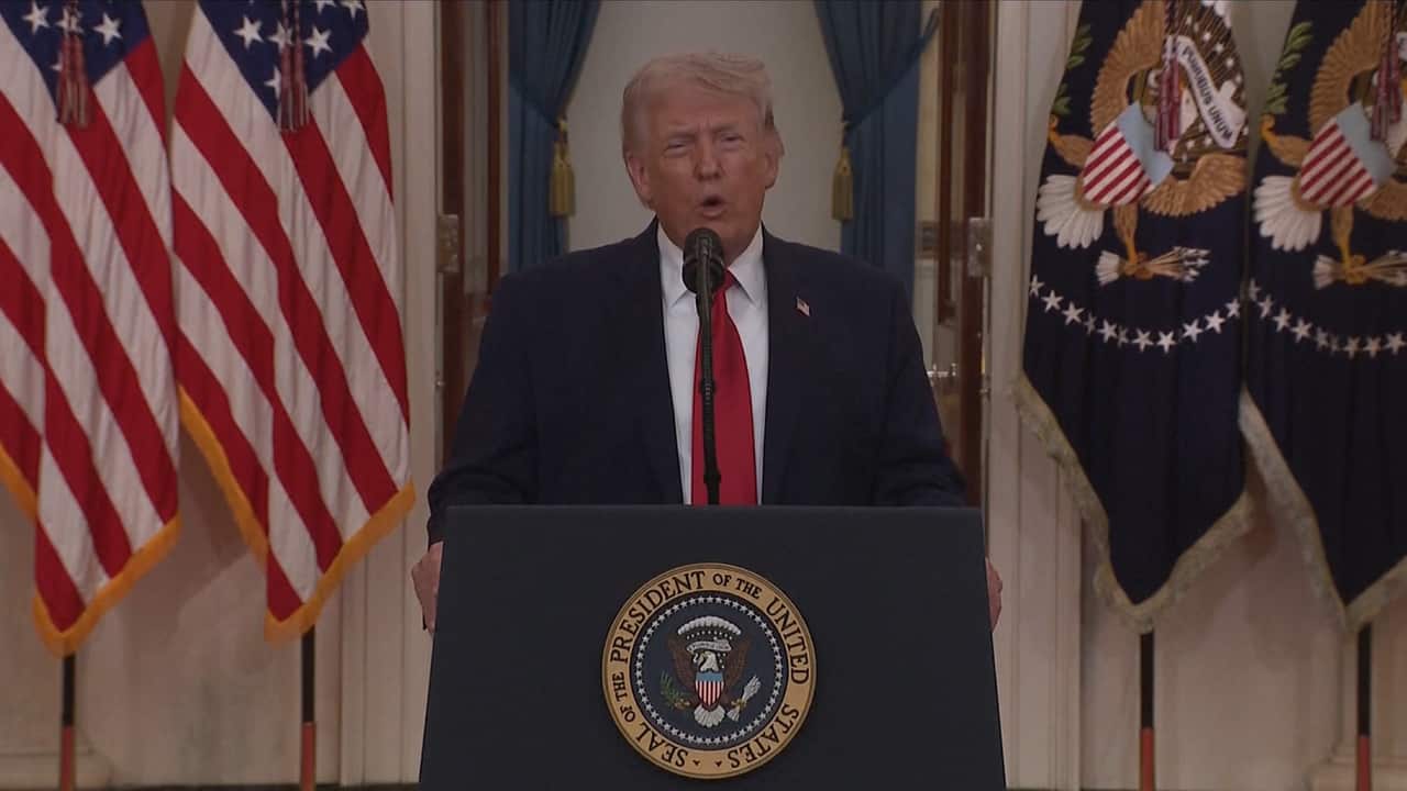 US President Donald Trump standing at a lectern speaking