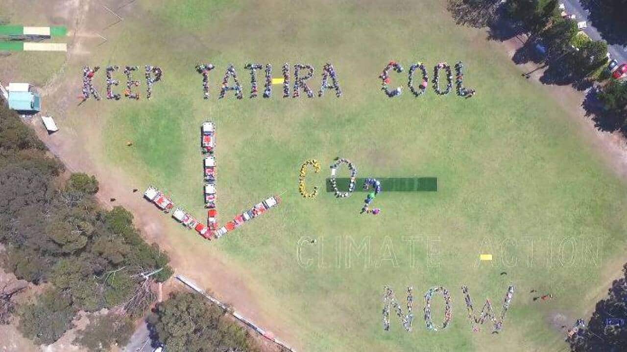 More than 2000 people have formed one of Australia’s largest human signs in Tathra, NSW, calling for stronger climate action and rapid reductions.