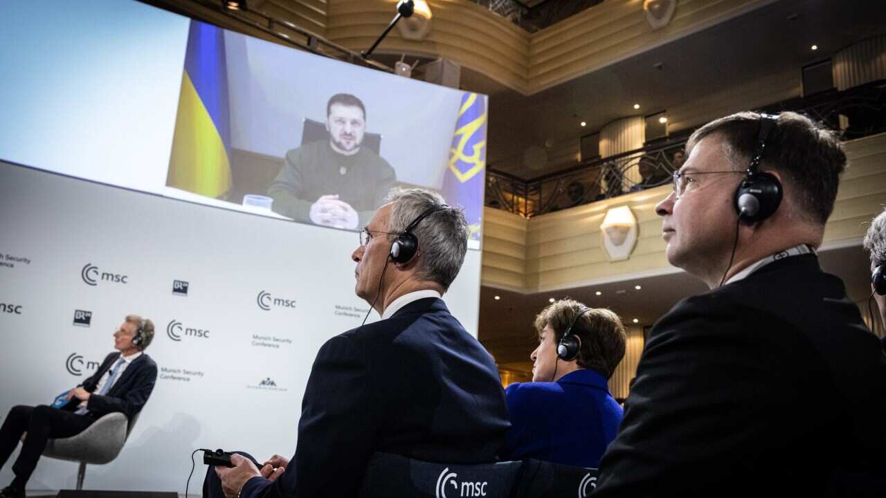 NATO Secretary General Jens Stoltenberg (C), Christoph Heusgen (L), Chairman of the Munich Security Conference, and European Commissioner for Trade Valdis Dombrovskis (R) listen to Ukrainian President Volodymyr Zelensky (pn screen) during the 59th Munich Security Conference (MSC)