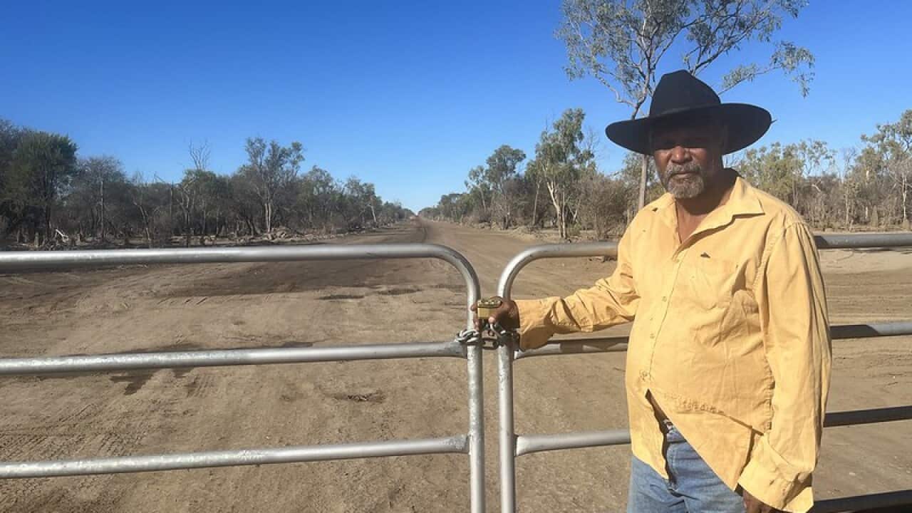 johnny wilson stands at the locked gate