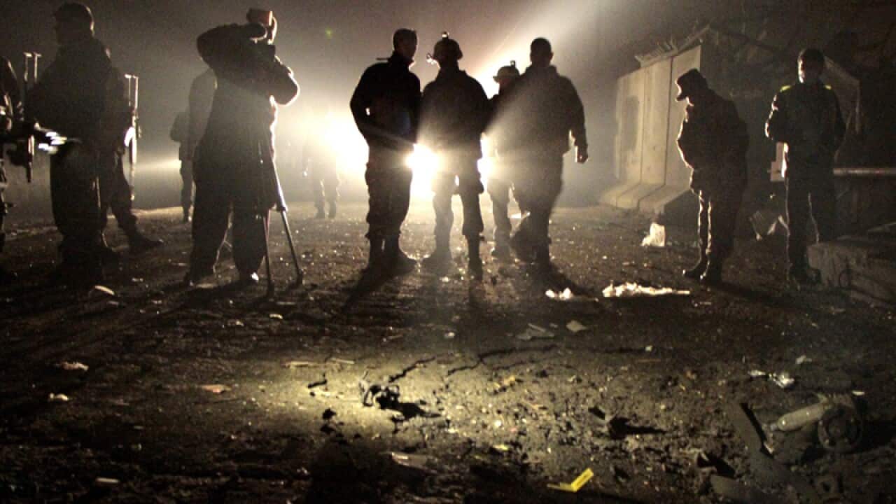 Afghan security officials at the site of a suicide bomb attack