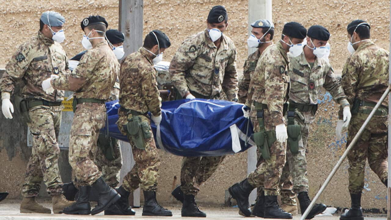 Italian soldiers carry the body of a victim of a shipwreck