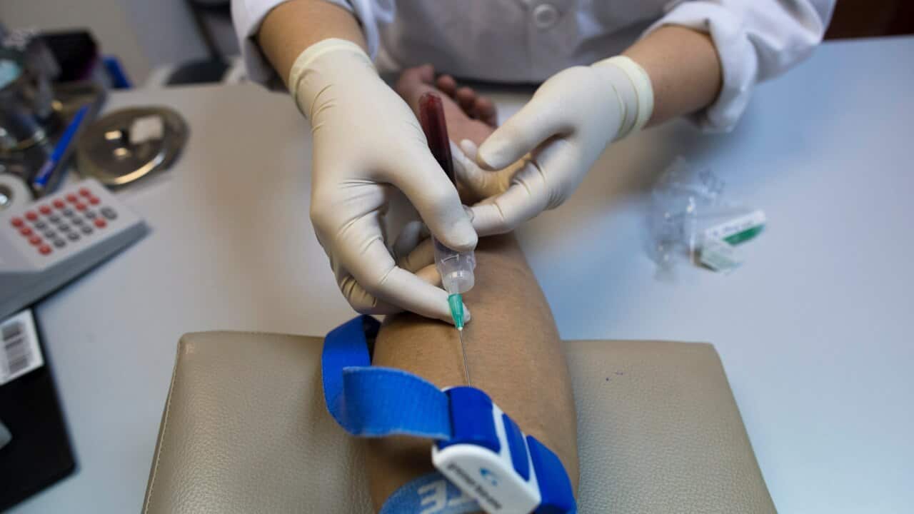 A health worker takes a blood sample for HIV.