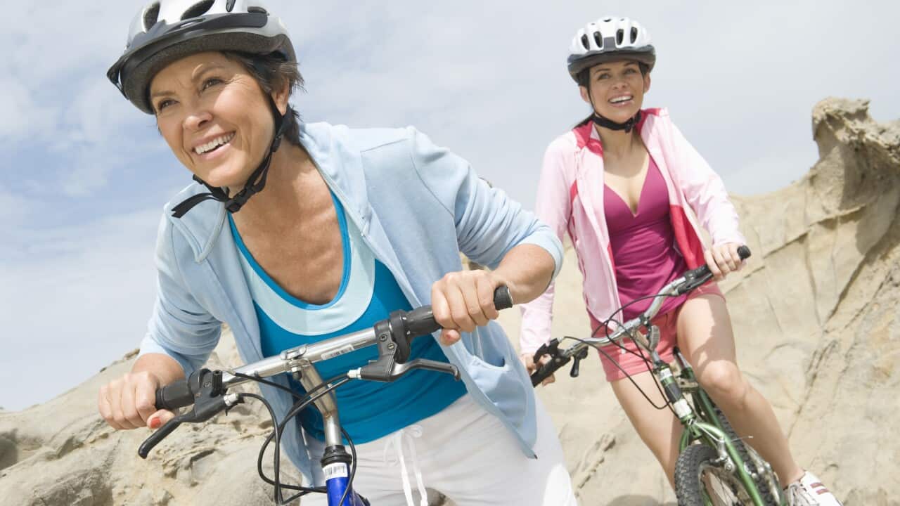 Mature and mid adult women compete on a cycle ride. (AAP)