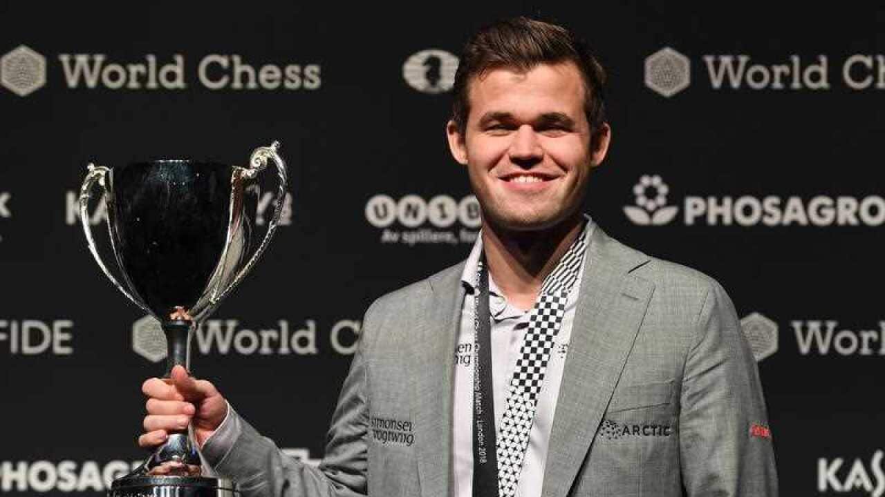 Norway's World Chess Champion Magnus Carlsen poses with the trophy after winning the World Chess Championships 2018 against US challenger Fabiano Caruana.