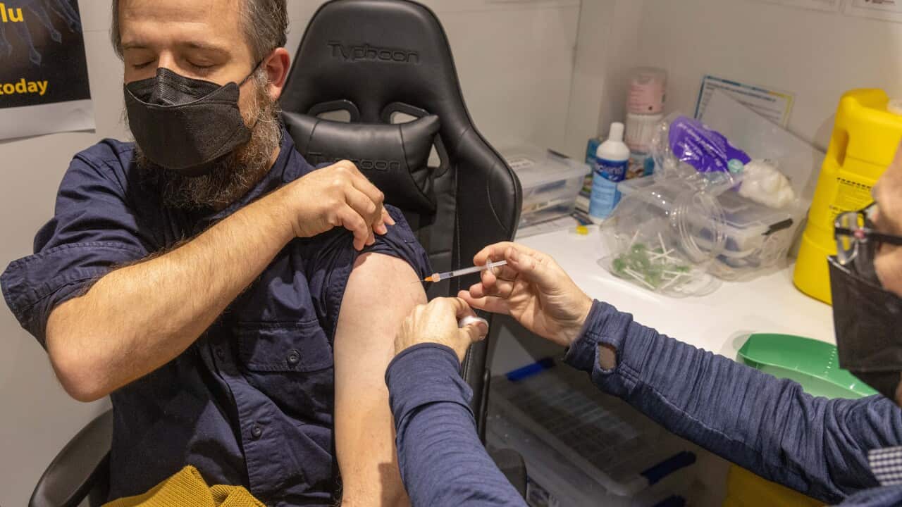 Un farmacista amministra una dose di richiamo di vaccino contro il COVID-19.