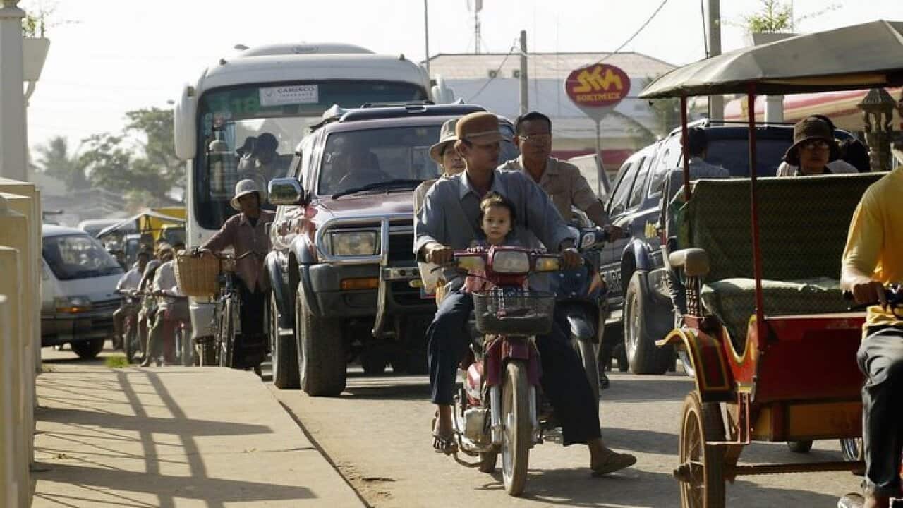 A plethora of vehicles jams a small bridge over the river in Siem Reap, August 24, 2004. Siem Reap, home to the famous Angkor temple complex and Cambodia's cultural capital, has become cluttered with construction and tourists. (AP Photo/Andy Eames)