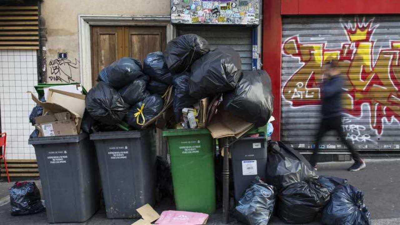 A man walks past a pile of rubbish bags in Paris, France, Wednesday June 8, 2016.
