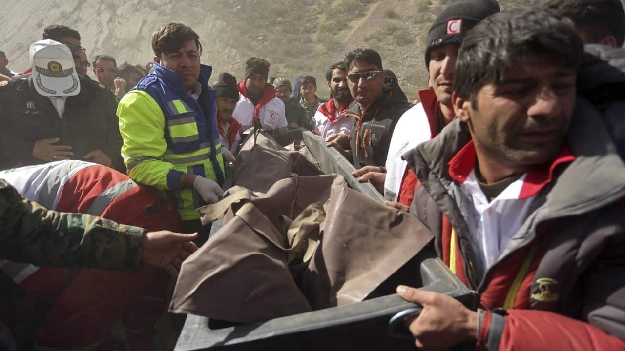 Rescue team members carry the body of a passenger of a Turkish private jet that crashed.