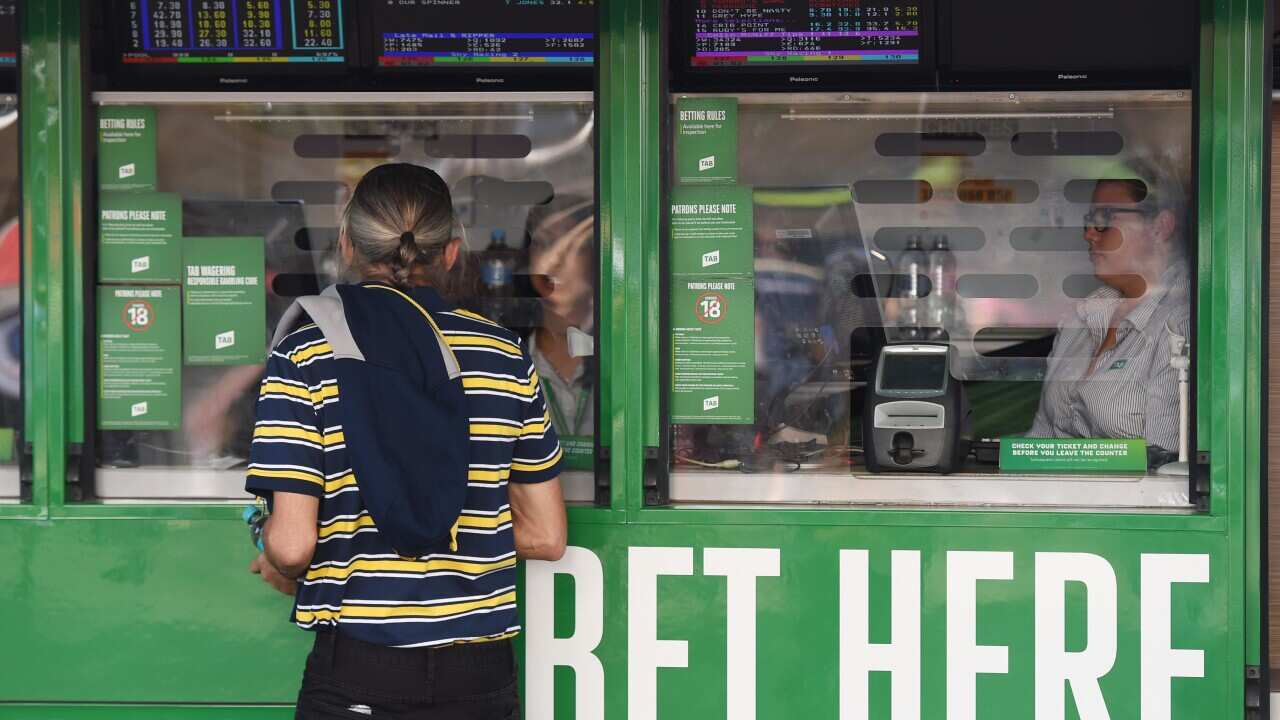 A North Queensland Cowboys supporter places a bet prior to the NRL Grand Final between the Brisbane Broncos and the North Queensland Cowboys at ANZ Stadium in Sydney on Sunday, Oct. 4, 2015. (AAP)