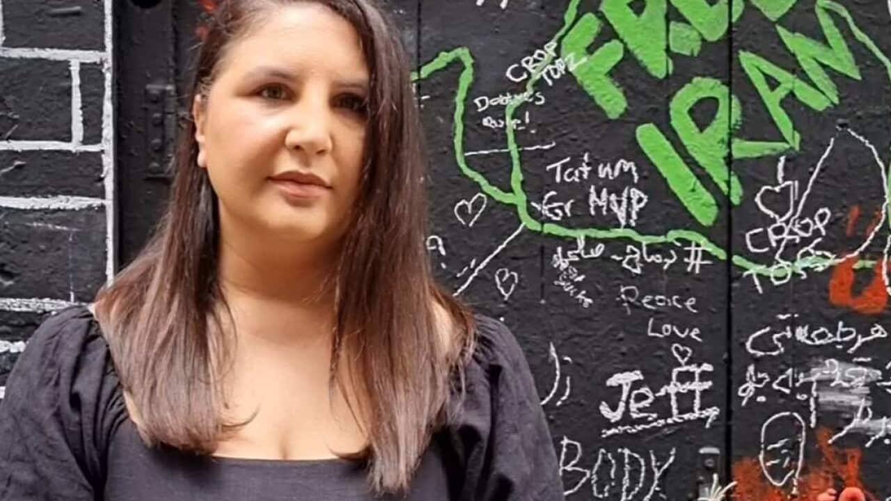A woman standing in front of messages of protest