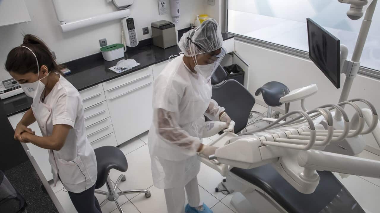 Dentist and her assistant prepare for a dental appointment