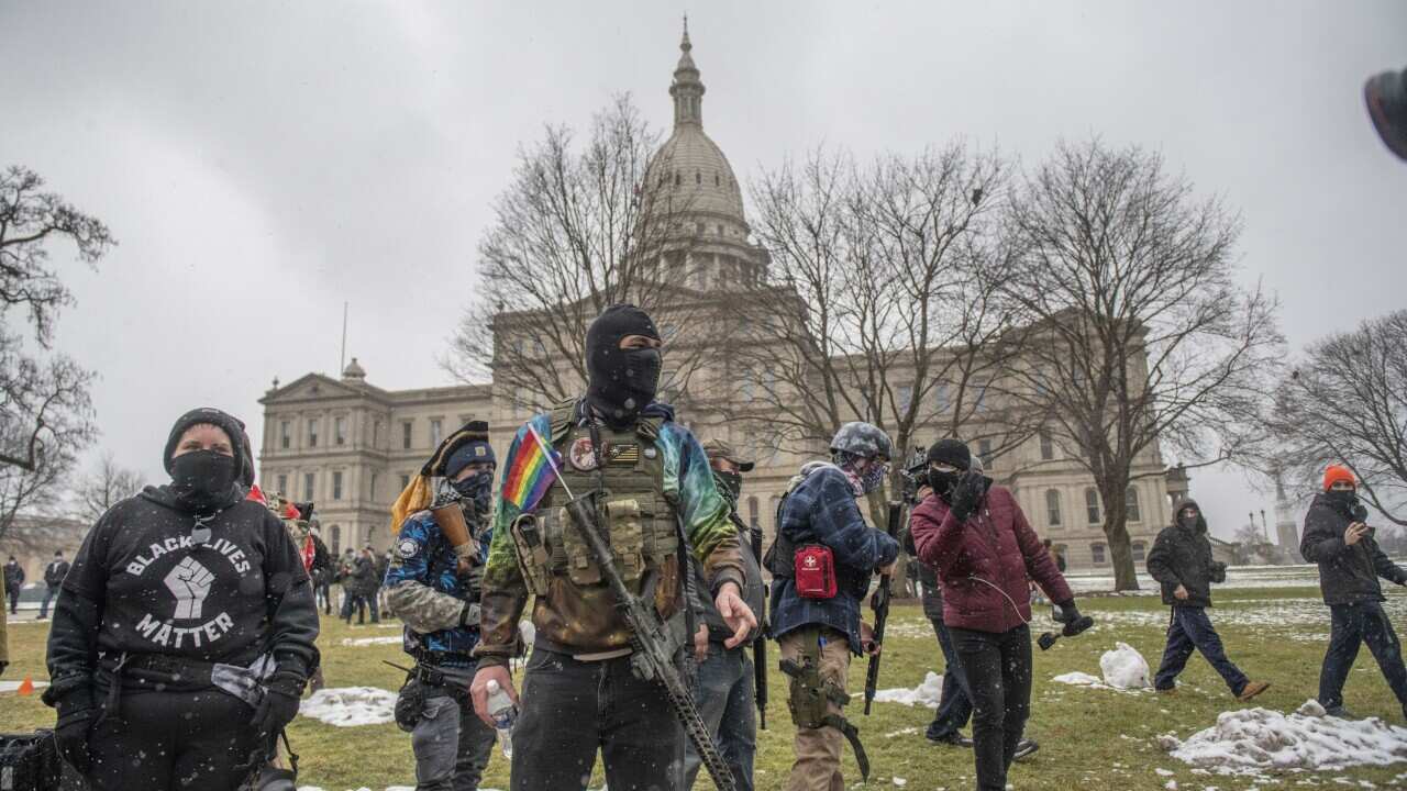 Members of the Boogaloo Bois leave the Capitol building Sunday, Jan. 17, 2021, in downtown Lansing, Mich. (Nicole Hester/Ann Arbor News via AP)