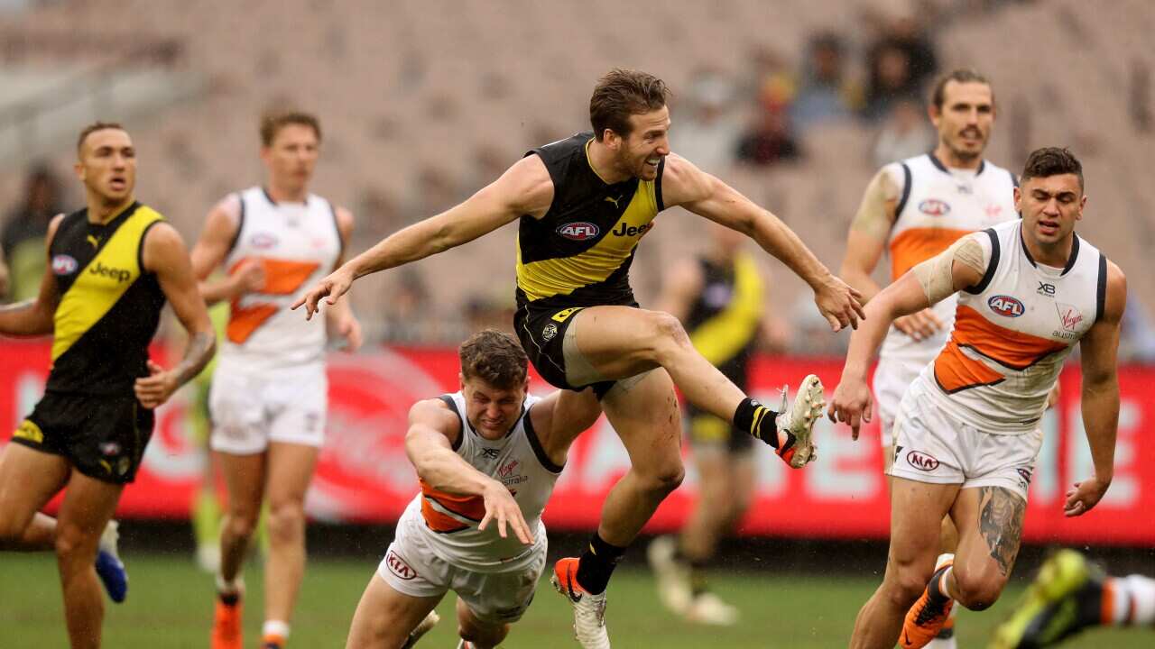 Kayne Lambert of the Tigers snaps for goal during the Round 17 AFL match between the Richmond Tigers and the GWS Giants at the MCG in Melbourne, Sunday, July 14, 2019. (AAP Image/Mark Dadswell) NO ARCHIVING, EDITORIAL USE ONLY