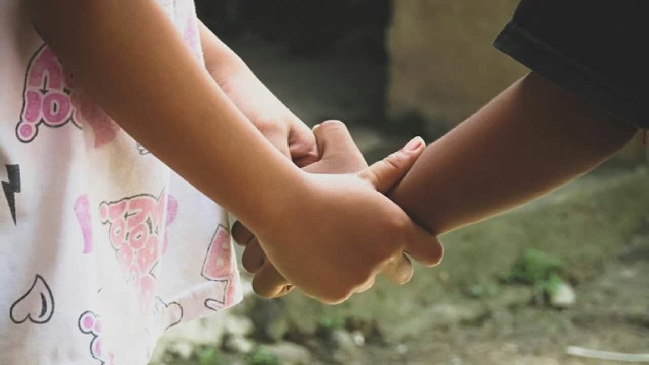 Close-Up Of Children Holding Hands Outdoors