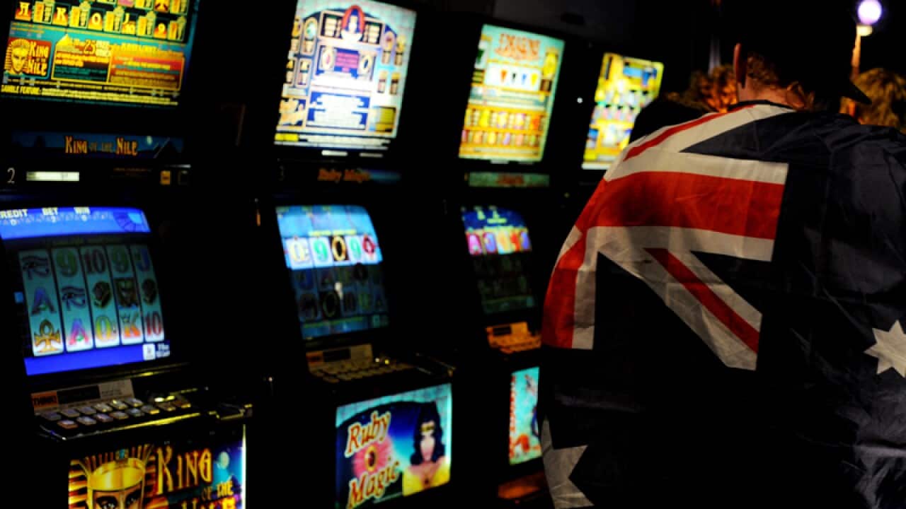 Punters use poker machines inside a hotel