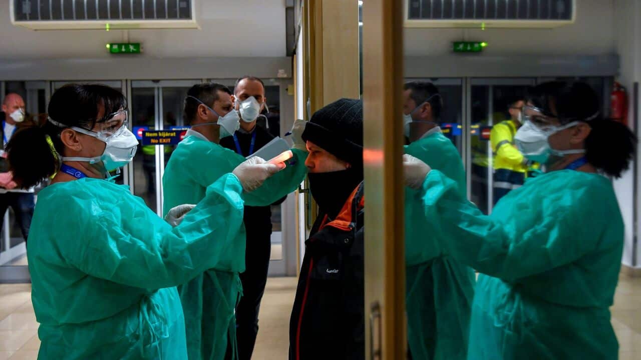 Airport staff check the temperatures of passengers returning from Milan as part of the coronavirus screening procedure at the Debrecen airport, Hungary.