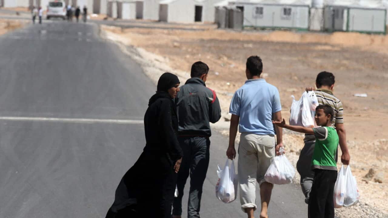 A Syrian refugee family walks towards the Azraq camp