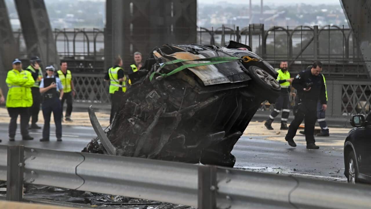 A car that caught fire is flipped over at the scene of a multi-vehicle crash on the Sydney Harbour Bridge in Sydney, Monday, March 7, 2022.