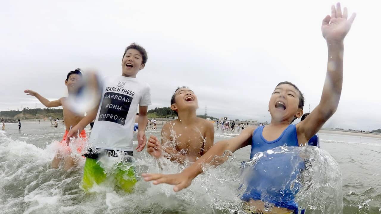 Children play in the water at Kitaizumi Kaisui beach in Minamisoma, Fukushima.