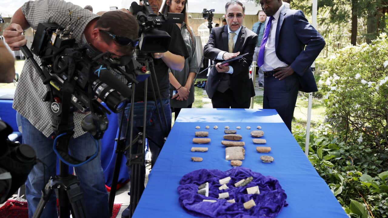 Ahmed Utaifa, with the Embassy of Iraq, center, talks with reporters about the ancient cuneiform tablets from Iraq being returned by the US.