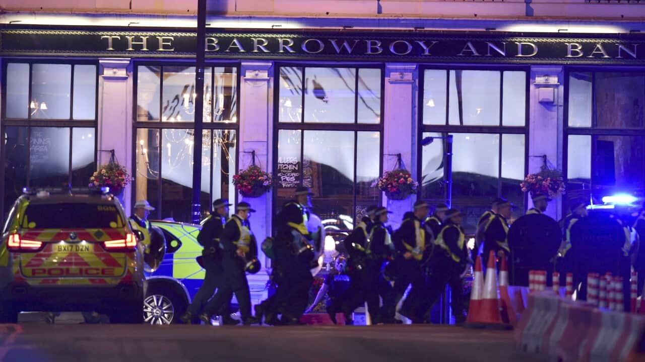 Police gather outside the Barrowboy and Banker Public House on Borough High Street in central London.