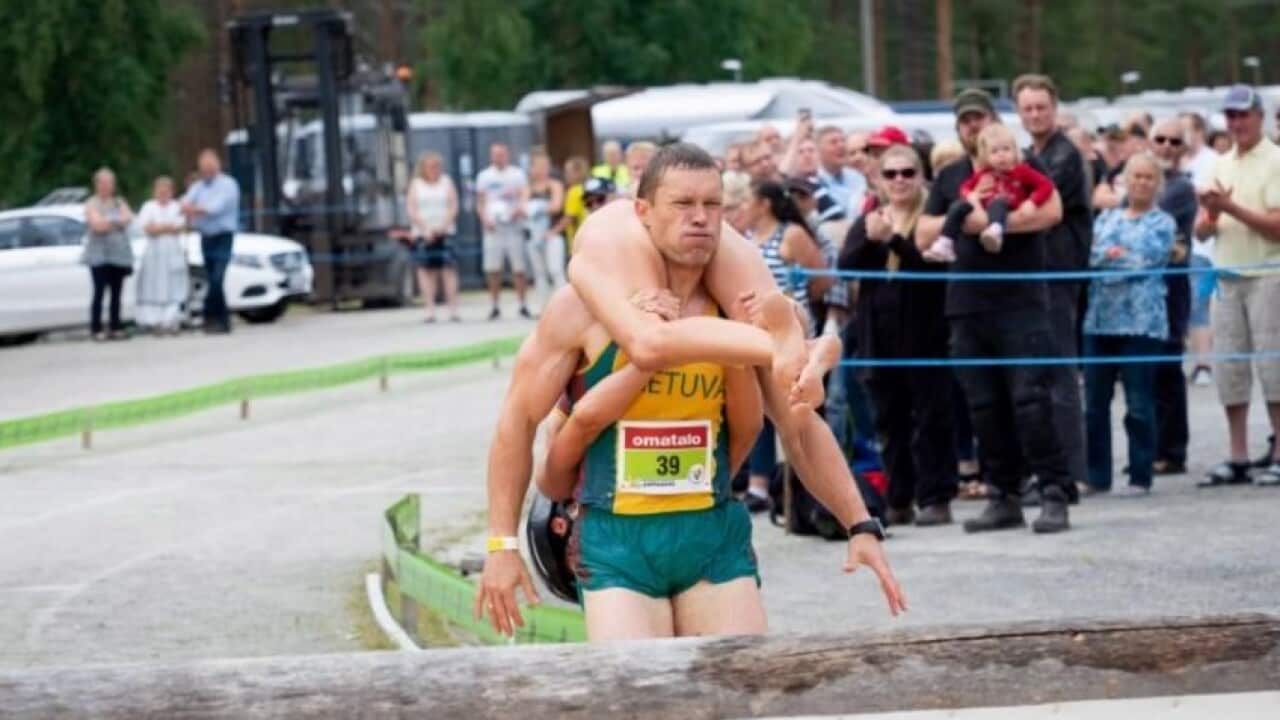 Vytautas Kirkliauskas of Lithuania carries his wife Neringa Kirkliauskiene as they compete during the Wife Carrying World Championships 2018 in Finland.