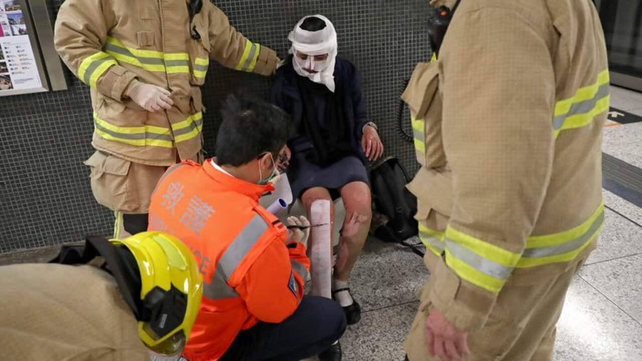 A commuter receiving first aid treatment from firefighters in Tsim Sha Tsui metro station in Hong Kong. A man hurled a firebomb on a crowded subway train.