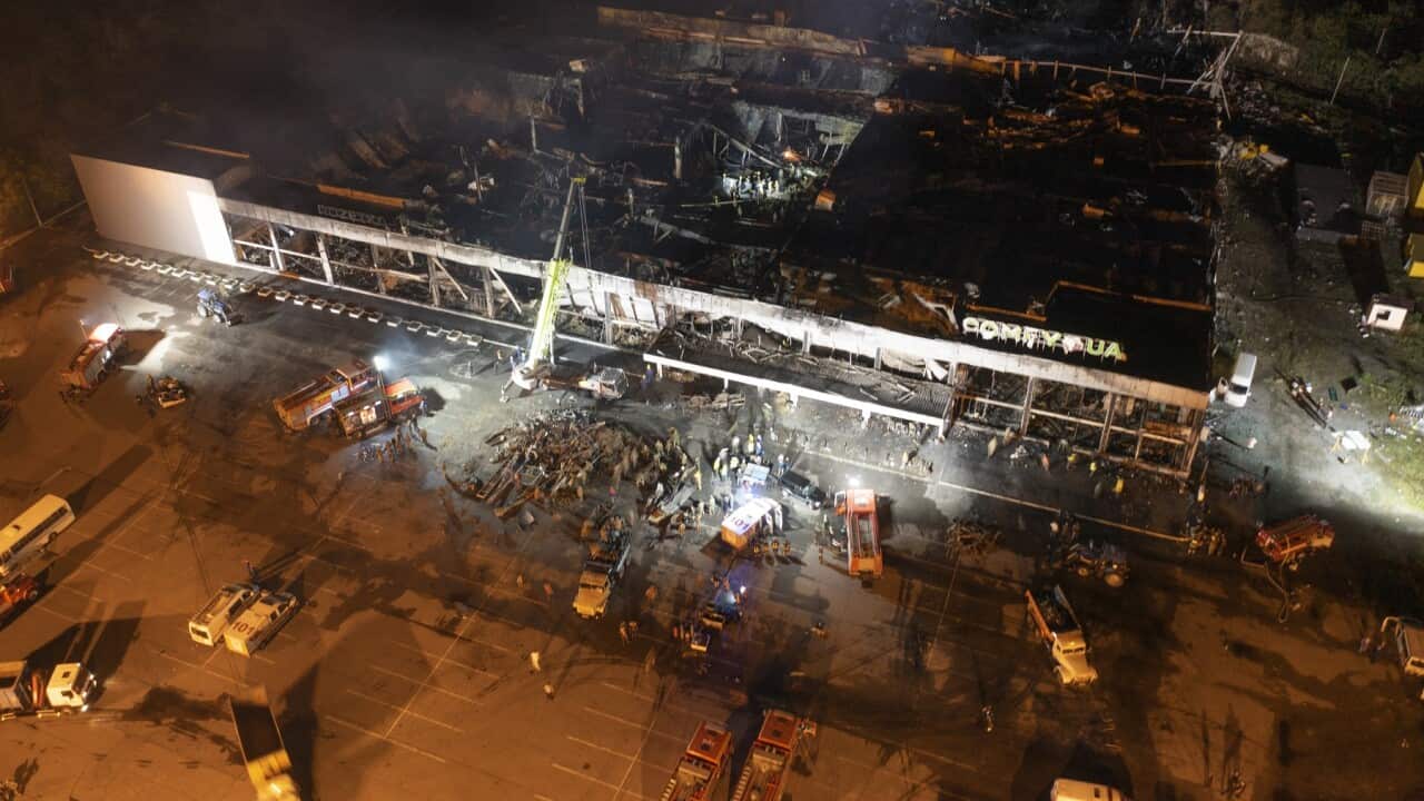 Firefighters work to extinguish a fire at a shopping centre after a rocket attack in Kremenchuk