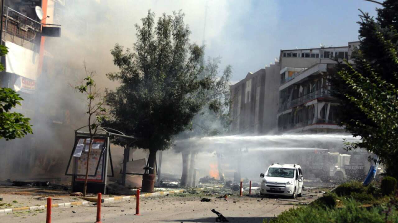 Firefighters work to extinguish a fire after a car bomb attack