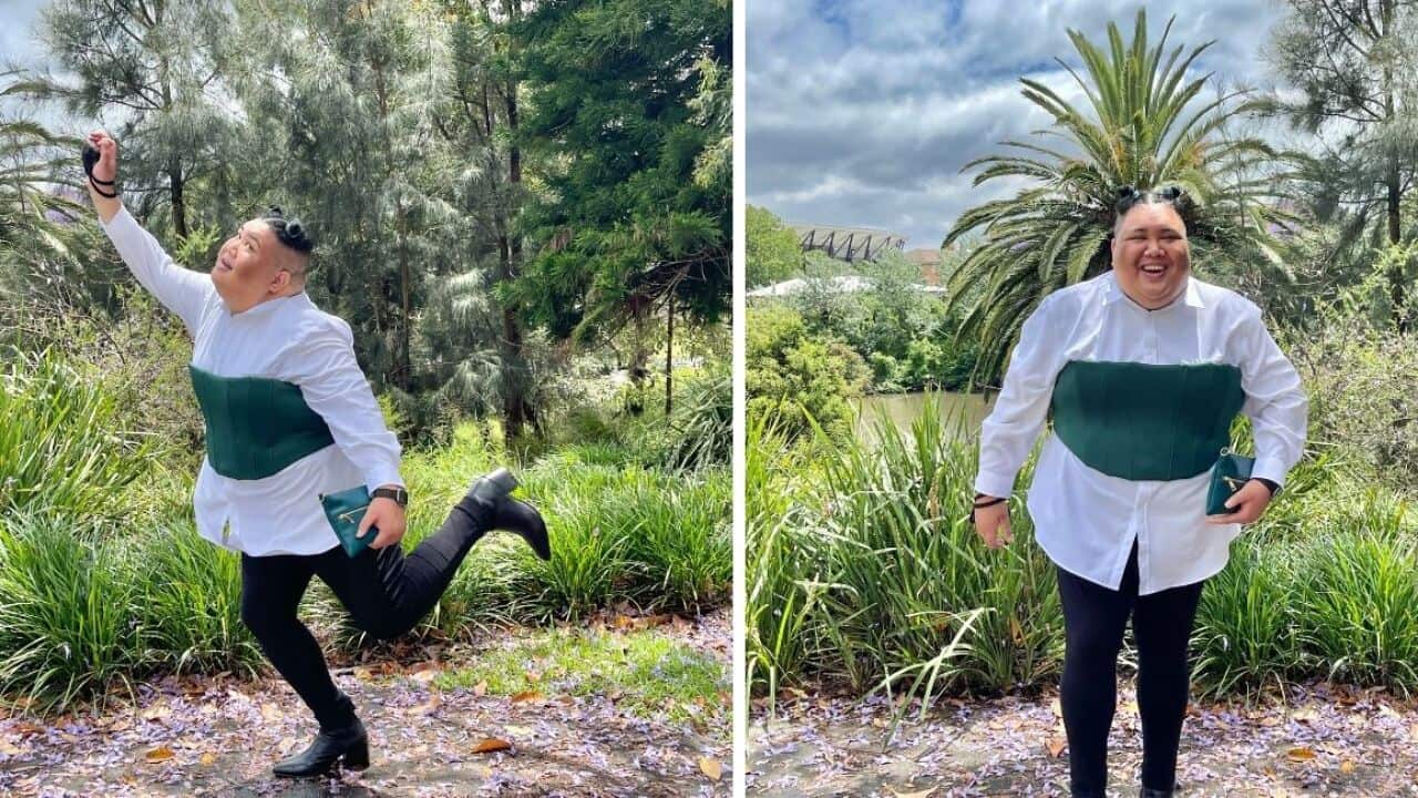 Mark Mariano in black pants, heeled boots, a white button down shirt with a green corset over the top. On the left he is posing and looking away from the camera. On the right he is laughing and looking towards the camera.
