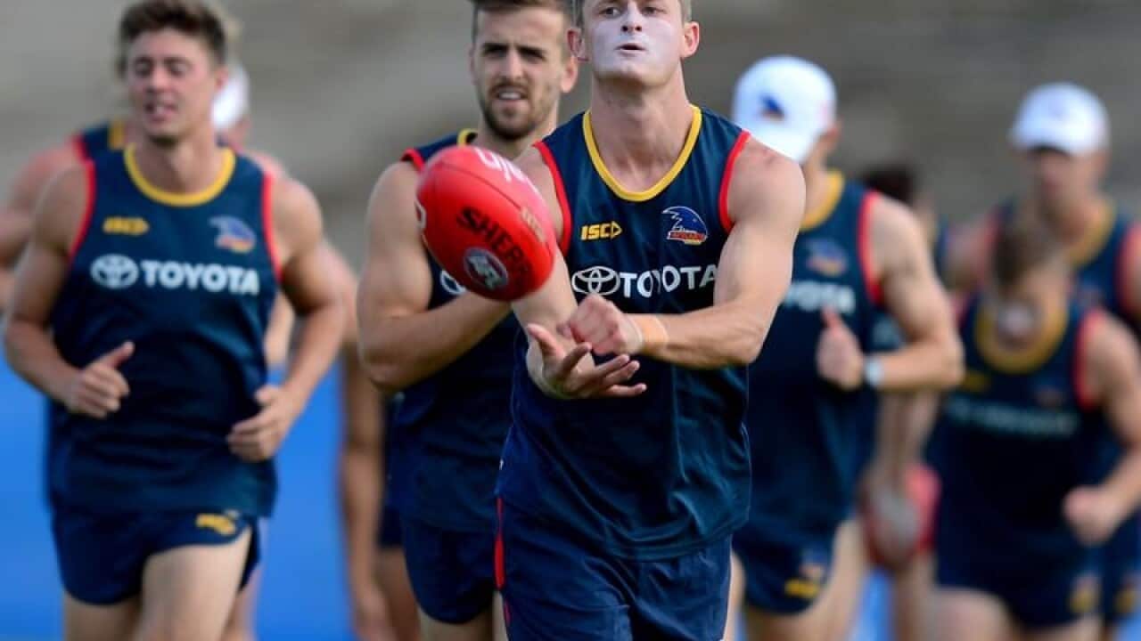 Matt Crouch handballs at training