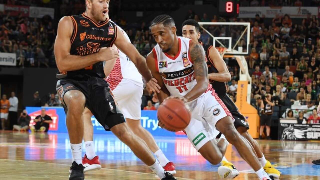 Bryce Cotton of the Wildcats (right) attacks