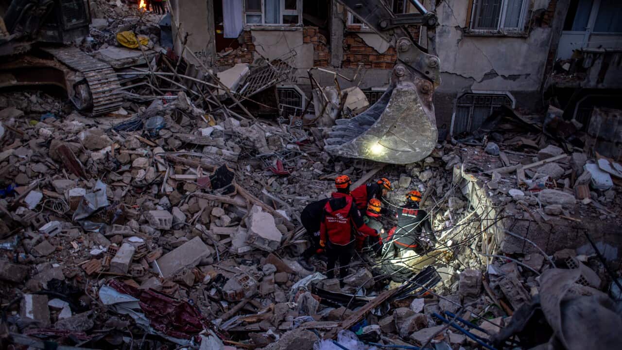 Rescue teams search for survivors at a site of collapsed buildings following an earthquake.