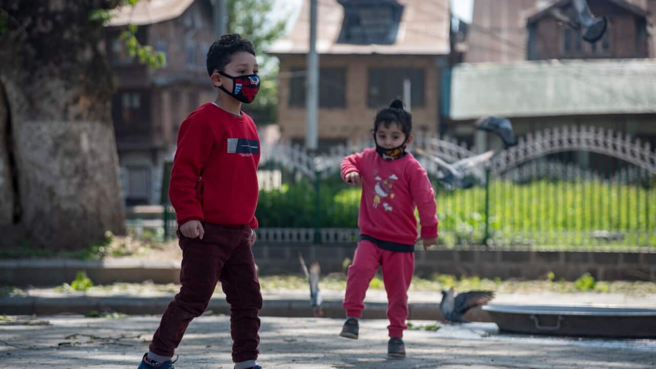 Children wearing face masks play during a one day curfew to curb the spread of COVID-19 in Srinagar.