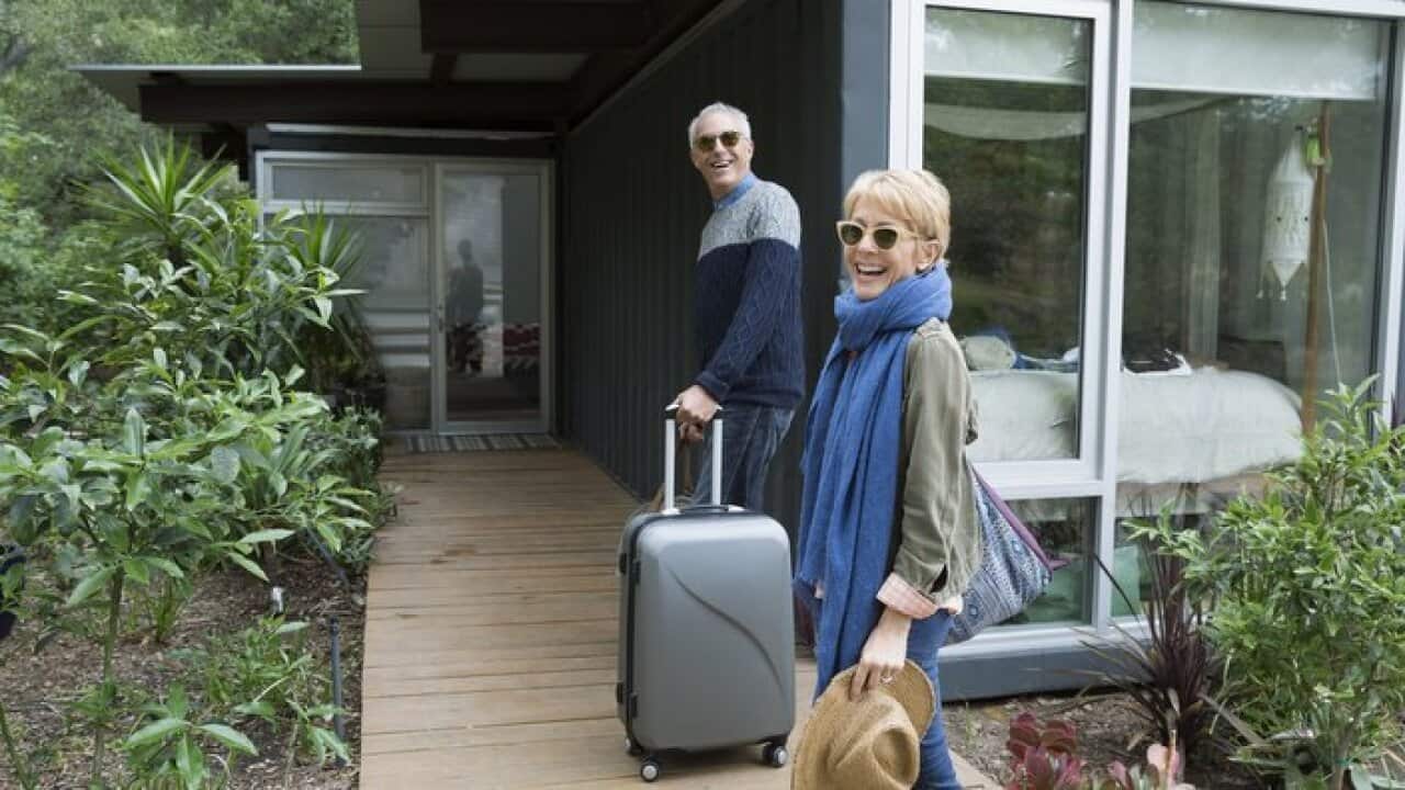 Mature couple with suitcases arriving at vacation rental