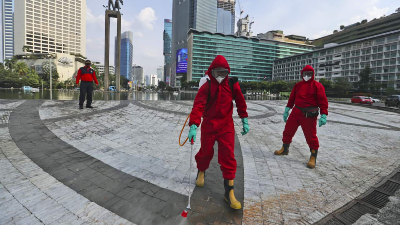 Firefighters spray disinfectant in Jakarta.