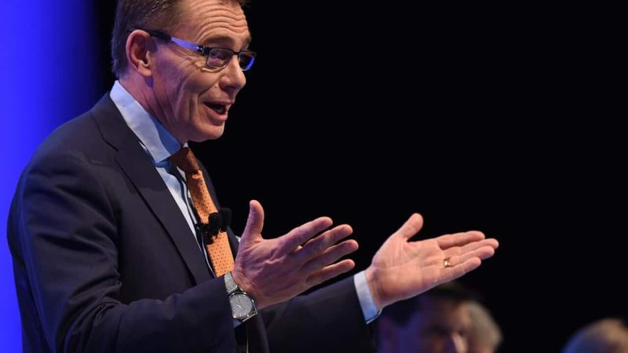 BHP Billiton CEO Andrew McKenzie with hands outstretched