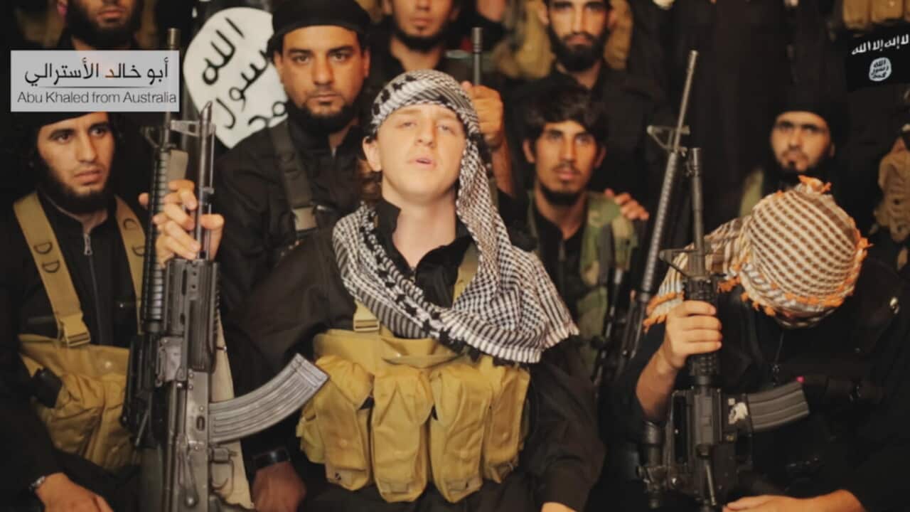 In the video, a man with an Australian accent is shown holding a rifle and wearing military clothing. He is named on the video as Abu Khaled from Australia. (Screenshot)