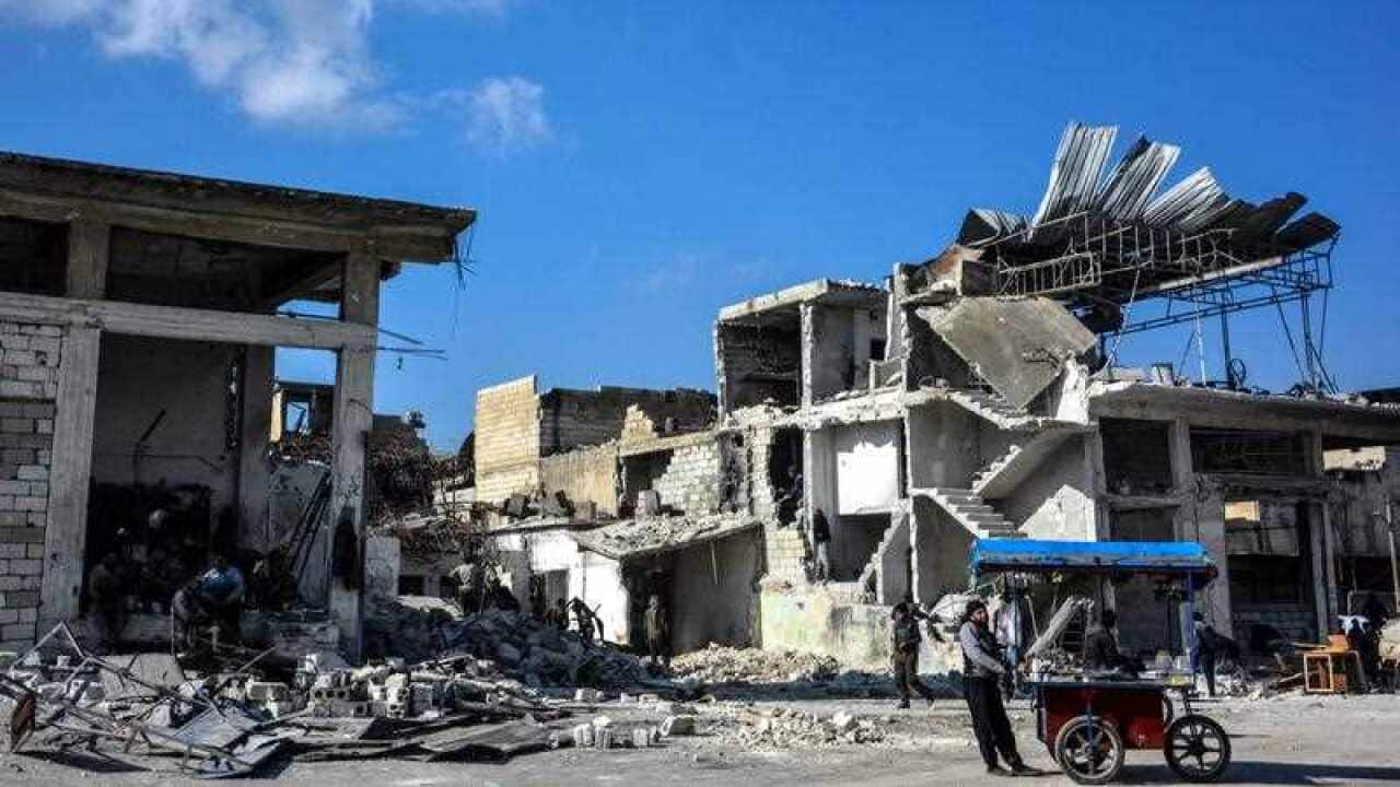 People inspect the rubble after airstrikes, at a marketplace in Idlib city, northwestern Syria, 29 January 2018.