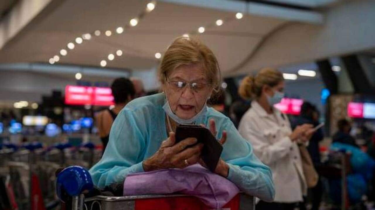 People line up to get on the Air France flight to Paris at O.R. Tambo airport in Johannesburg on November 26, 2021.