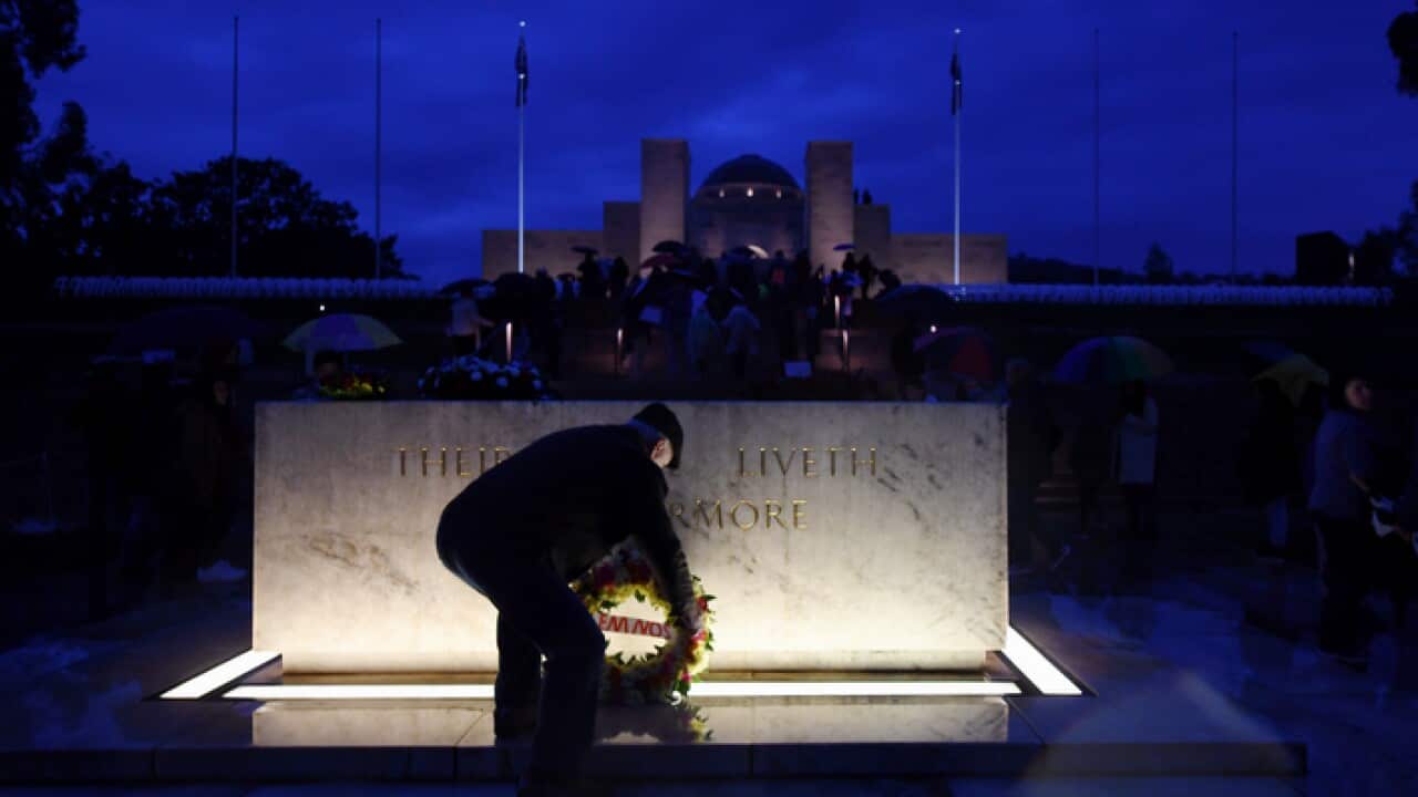 A man places a wreath at the stone of remembrance at the Australian War Memorial during the ANZAC Day dawn service in Canberra, Tuesday, April 25, 2017. (AAP Image/Lukas Coch) NO ARCHIVING