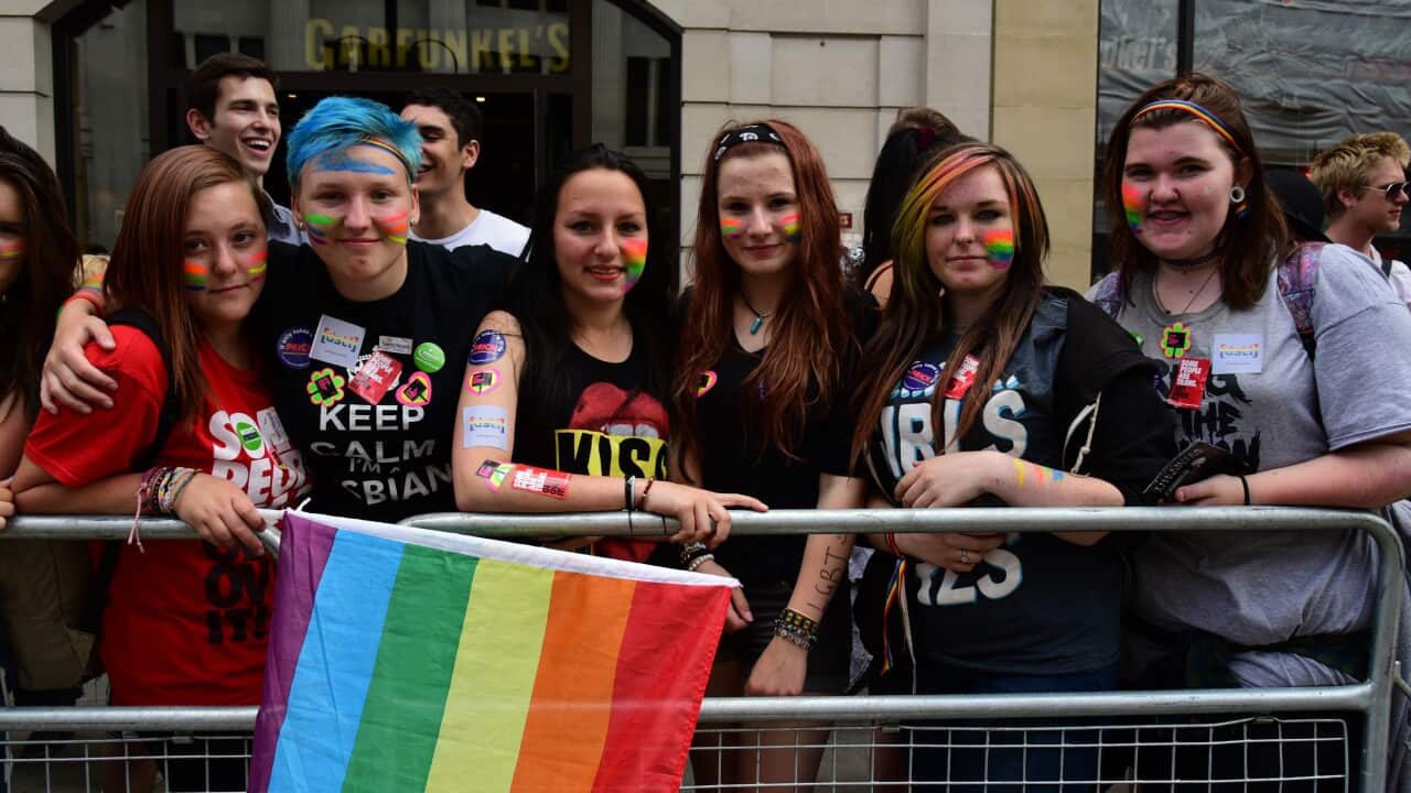 Young women hold a pride flag and pose for a photo as supporters of the LGBT community have taken to the streets of London, England for the annual Pride Parade on June 27, 2015.