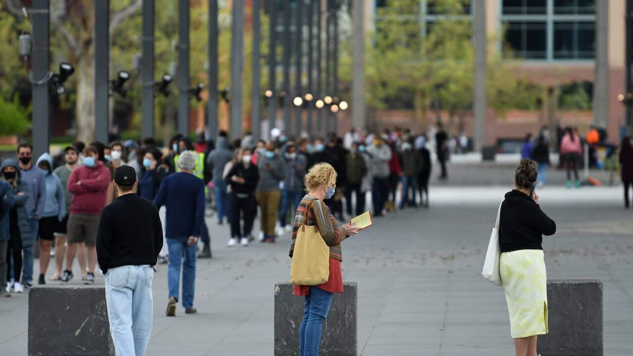 People are seen waiting in line at the Melbourne Museum COVID-19 vaccination clinic.