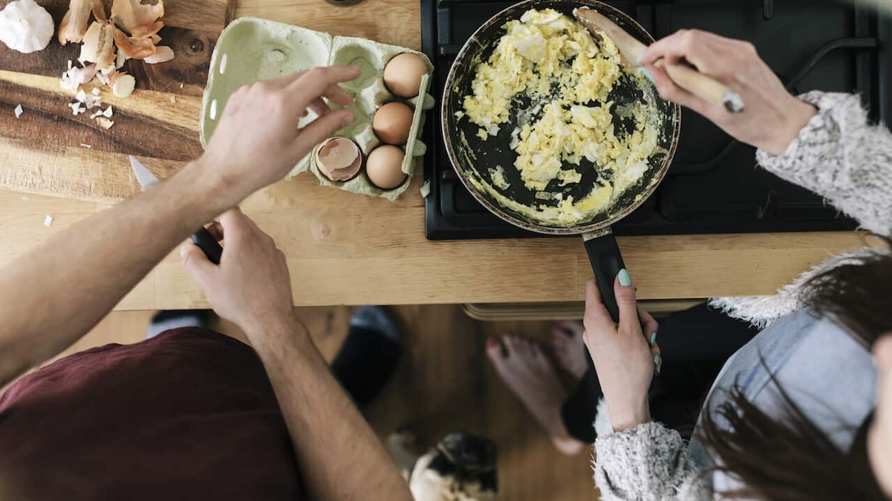 Overhead view of couple making eggs