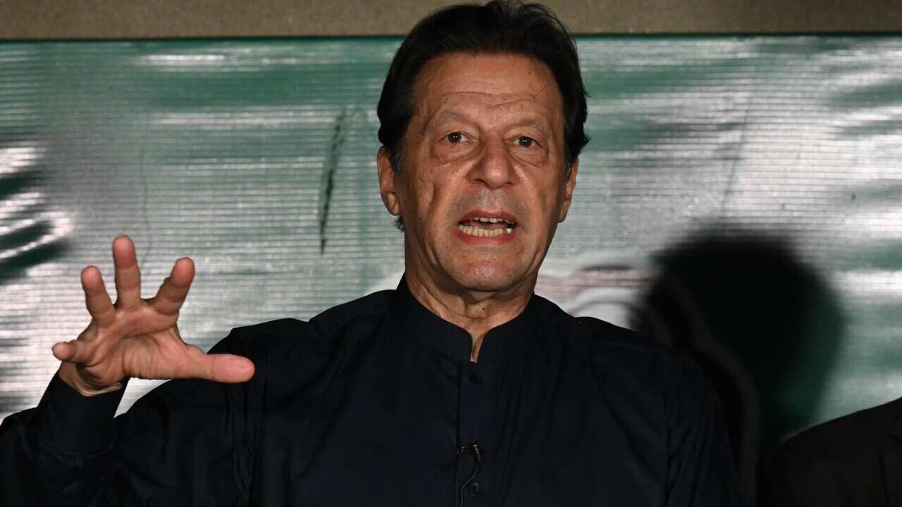 A man wearing a black shit speaks.