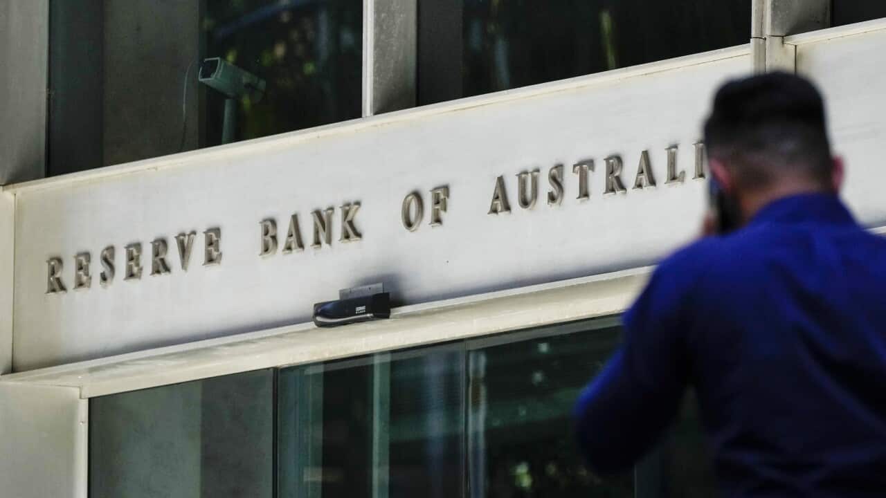 A man walking past a Reserve Bank of Australia office.