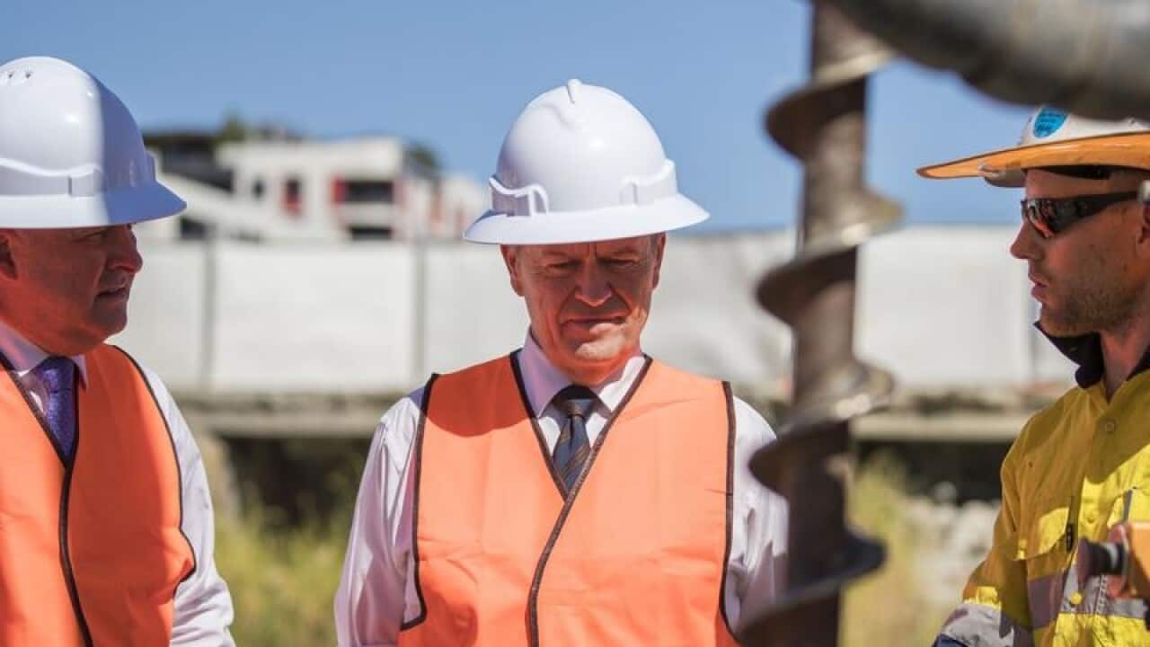 Anthony Albanse and Bill Shorten with a worker at a site in Brisbane.