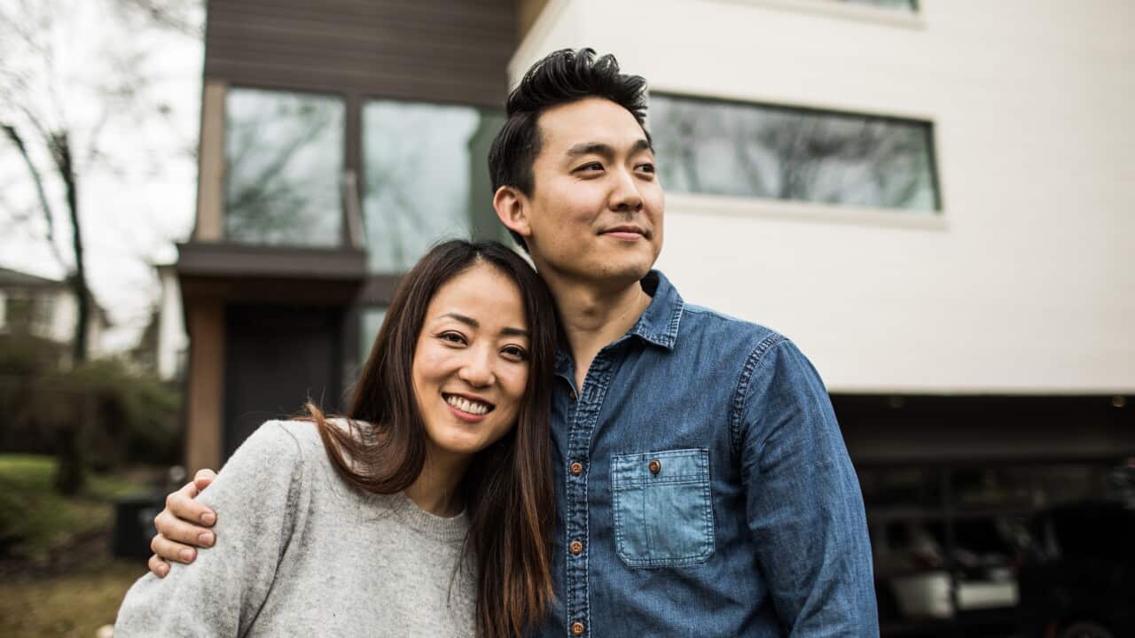 Portrait of young couple in front of new home